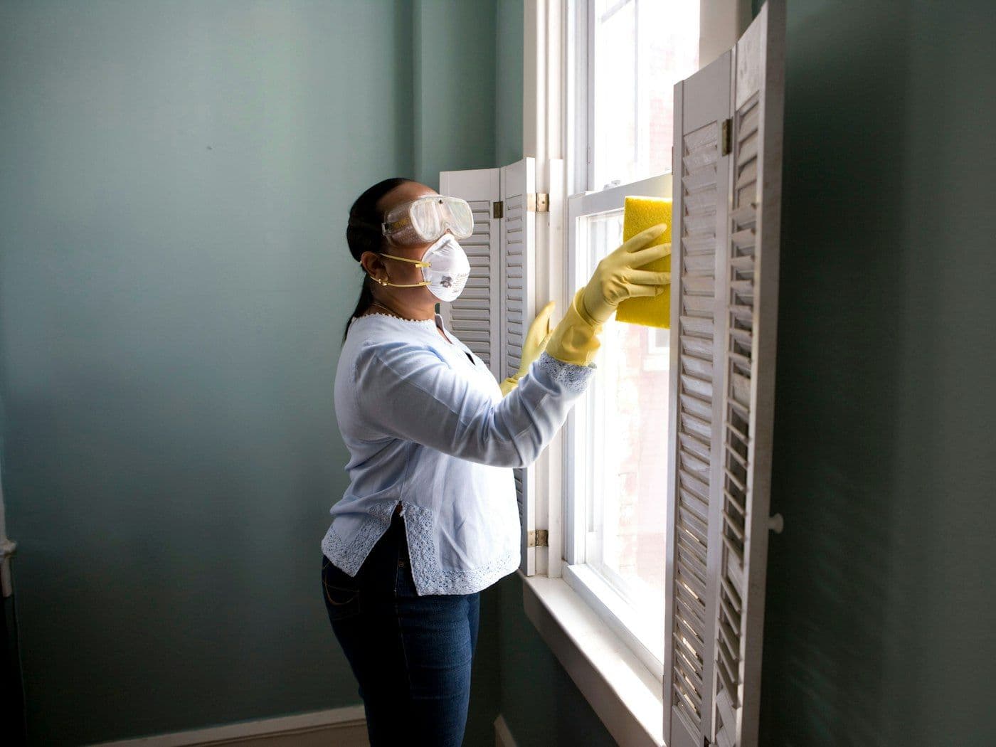 Fensterreinigung mit Handschuhen und Schwamm